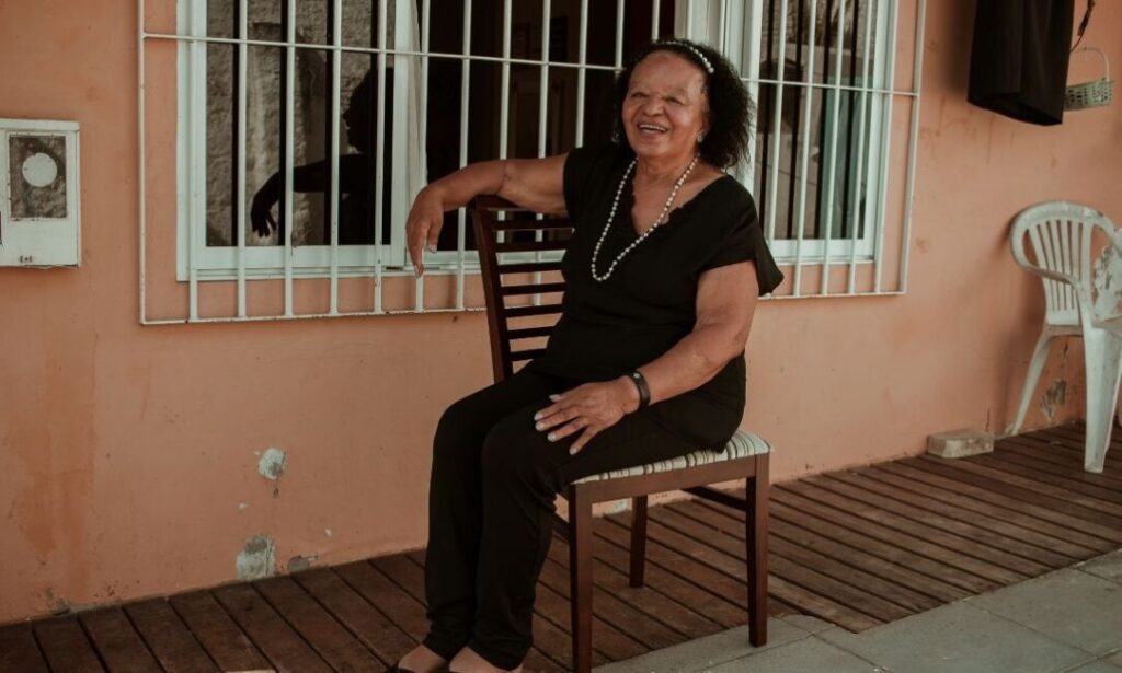 Dona Uda na área externa de sua casa.